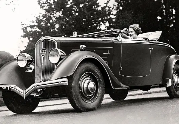 En kvinna kör en elegant cabriolet, ett exempel på gamla bilmodeller från 1930-talet.